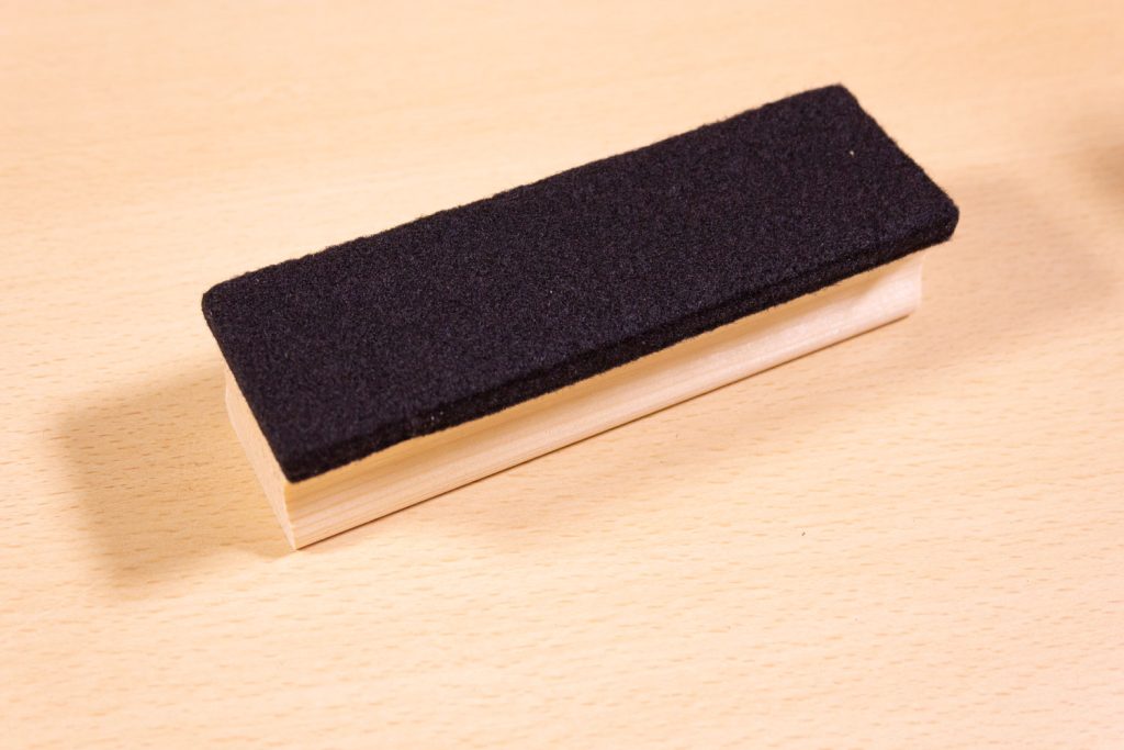 Image shows felt eraser on a desk.