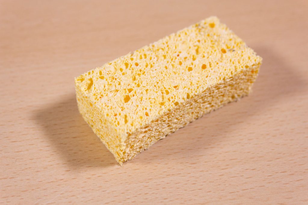 Image shows a cleaning sponge on a desk.